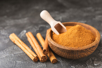 Ceylon cinnamon.Cinnamon sticks on a textured wooden background. Cinnamon roll and powder. Spicy spice for baking, desserts and drinks. Fragrant ground cinnamon. Close-up. Place for text. copy space