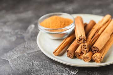 Ceylon cinnamon.Cinnamon sticks on a textured wooden background. Cinnamon roll and powder. Spicy...