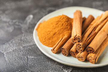 Ceylon cinnamon.Cinnamon sticks on a textured wooden background. Cinnamon roll and powder. Spicy spice for baking, desserts and drinks. Fragrant ground cinnamon. Close-up. Place for text. copy space