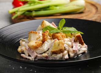 Plate of chicken salad and sliced tomatoes displayed on a table