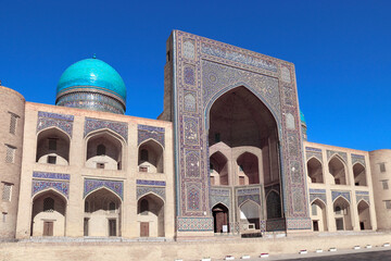 Facade of Mir i Arab madrassa, Bukhara, Uzbekistan. Madrasah Mir Arab, Poi-Kalyan (Poi Kalon) islamic religious complex in old town in Bukhara. Inscription above the entrance is a quote from the Koran