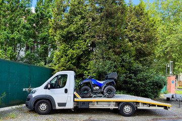 Fototapeta premium A blue ATV quad bike loaded into the back of a small car.