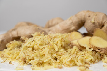 Pieces of finely grated fresh ginger root on kitchen board