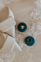 Wedding ring and white shoes on lace tablecloth