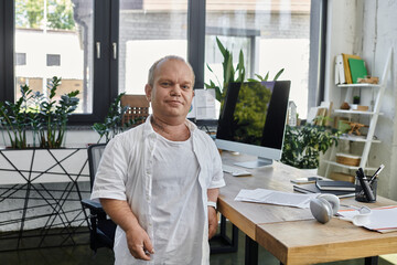 A man with inclusivity stands confidently in his office, showcasing the importance of diversity and inclusivity in the workplace.