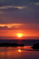 a sunset view with the sun in the background and there is a body of water