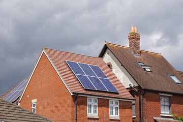 Residential houses with solar panels on roof. Photovoltaic solar cells. Energy and power sustainable source 