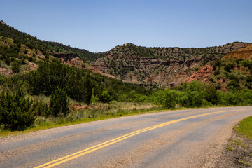 a winding road with a mountain in the background along it