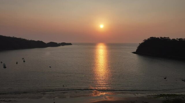 epic sunset with pink sky over the Pacific Ocean with some moored boats in El Jobo, Costa Rica