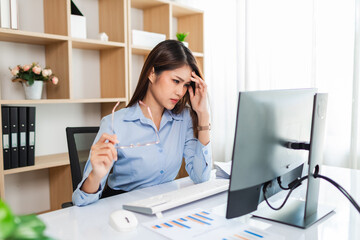 Tired overworked business asian woman or accountant working with a laptop in an office or home.