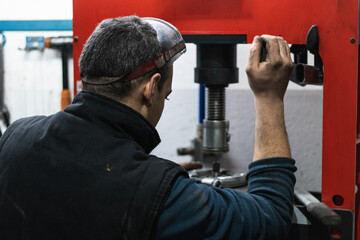 Car mechanic press new silentblock at repair service station. Auto service.