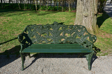 green metal bench with decorative backrest with vegetal ornamentation