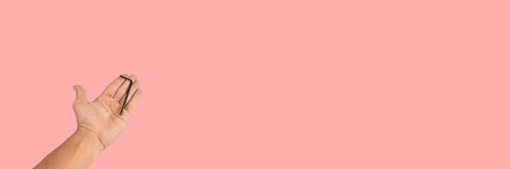 Black male hand offering an allen key isolated on pink background banner