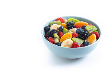 Fruit salad in a blue bowl isolated on white background. Copy space