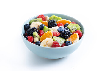 Fruit salad in a blue bowl isolated on white background