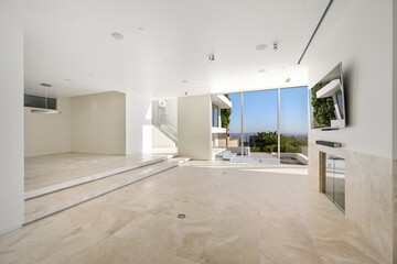 Fototapeta premium Spacious living room with a large flat-screen TV mounted on a white wall. California, USA