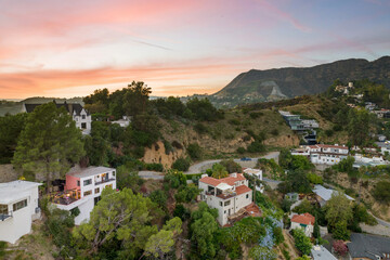 Scenic view of green hills and suburban homes in Los Angeles at sunset, California