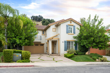 Two-story house with a garage and front yard trees. California, USA