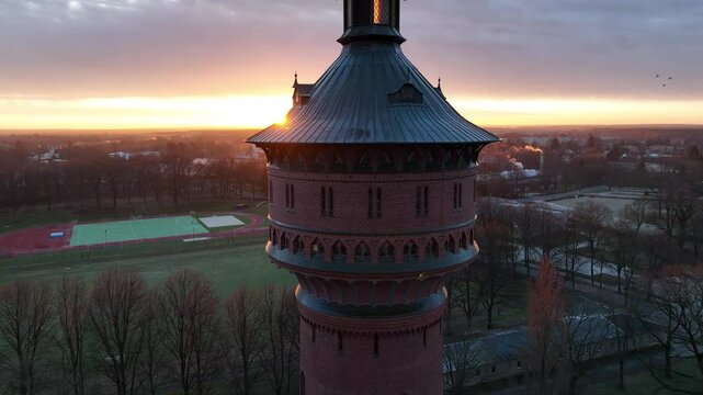 Pull-back drone footage of the historical Water Tower (Wasserturm) at sunrise in Forst town, Germany