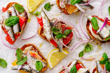 Crostini with sardines, tomatoes, mayonnaise and basi .top veiw