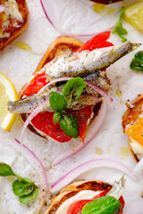 Crostini with sardines, tomatoes, mayonnaise and basi .top veiw