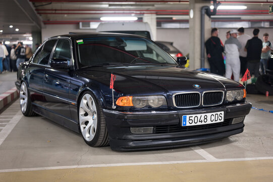 German car BMW E38 in dark color with the German imperial eagle flag on the front wings.