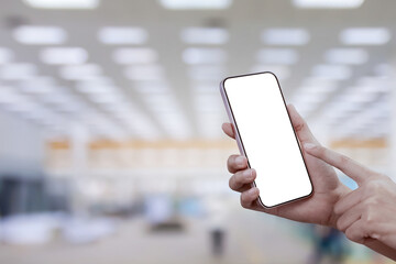 Close-up of a woman hand holding a smartphone white screen at factory background. Transparent...