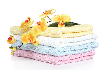 Stack of folded towels with a vibrant yellow flower accent