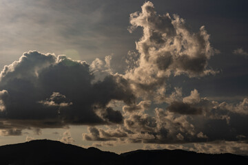 Mountain landscape with Dark clouds before the rain,Dark stormy clouds and the sun shining through.