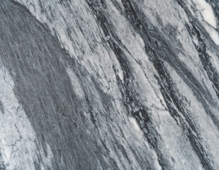 Gray marble texture with natural white veining patterns. Smooth, polished stone surface for countertops