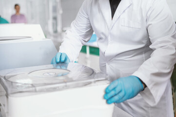  Container for tubes of biochemical analyzers Doctor removes from lab centrifuge.  Unrecognizable doctor holds in hands clinical chemistry samples putting them to centrifuge