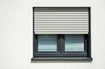 Moderne Fenster in einer verputzten und gestrichenen Fassade eines modernen Wohnhauses