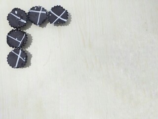 A bunch of chocolate bites on upper left corner of a table with copy space. Fit for food blogs, bakery promotions, dessert advertising, and social media posts.