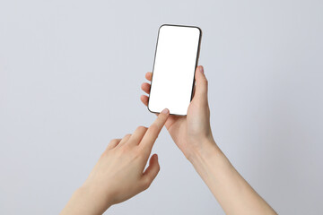 Female hands holding a smartphone on a gray background