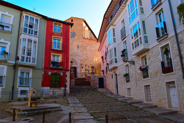 Tranquil, empty city square and street in Burgos with the San Gil church at golden hour