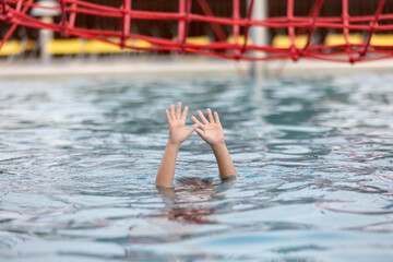 Hands of drowning person stretching out of the water in swimming pool needing help. Stress concept