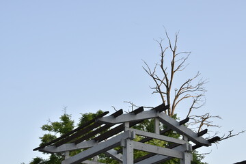 The roof of a wooden gazebo against the blue sky.