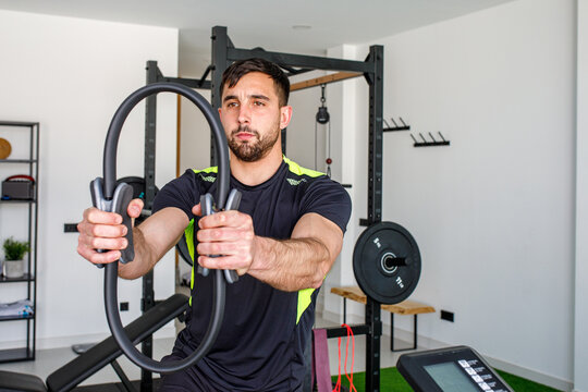 Man engaging in a workout using gym rings at home