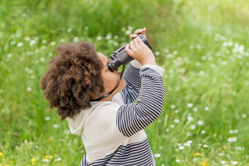 Young girl enjoying photography in a lush green park