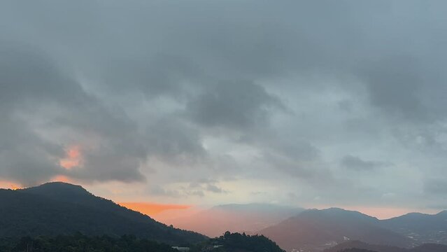 Gray clouds were moving quickly over the mountains and the sun was shining.