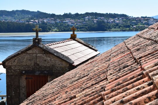 Horr&eacute;o in Combarro, Galicia, Spain - typical traditional grain barn of the region, surrounded by lush green foliage and with mountain range in the background