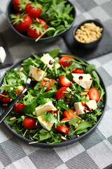 Summer salad with strawberries, arugula, Camembert cheese and pine nuts.