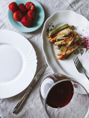 Lunch dinner homemade food. Baked zucchini, strawberry, glass of red wine. Photo