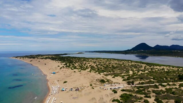 Aerial footage of the beautiful small town known as St George South, Greek city of Corfu Greece, showing the Issos Beach with mountains in the background