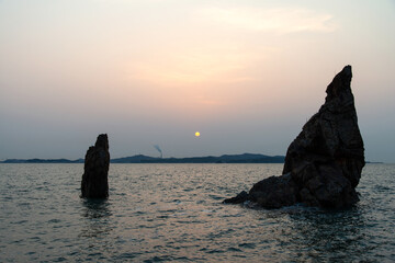 View of the sunset with the rock on the sea
