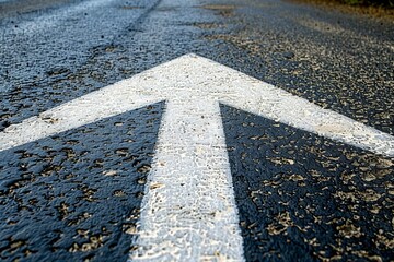 Upward white arrow on wet asphalt road