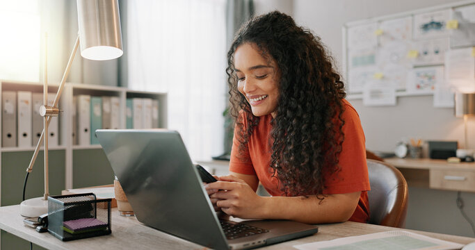 Business woman, laptop and smile for phone, communication and networking for startup in office. Happy, female employee event planner checking email on computer, social media and post on smartphone - Powered by Adobe