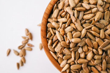 Sunflower seeds in wooden bowl isolated on white background