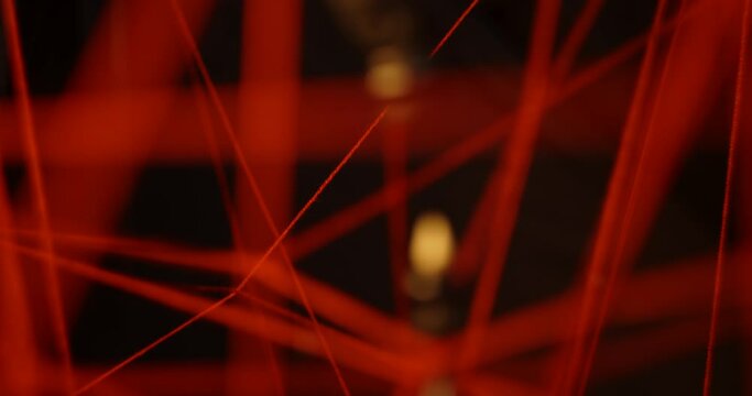 Among the stretched red threads on a black background in a three-dimensional space hangs a chess piece of a black knight above a figure of a queen entangled in a thread. Psychology and psychiatry