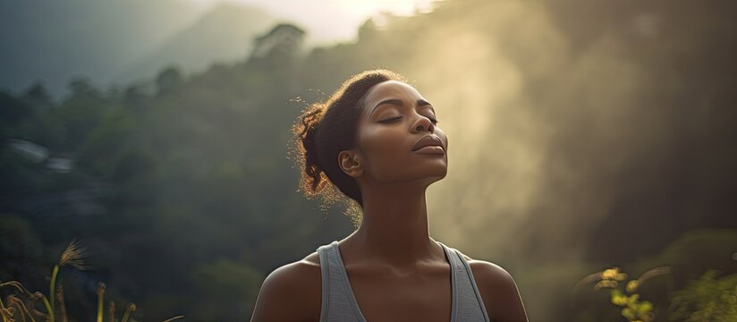 Black female taking a breath outdoors with copy space image in nature for mental well-being, combining fitness, meditation, and outdoor activities for a sense of freedom and energy.